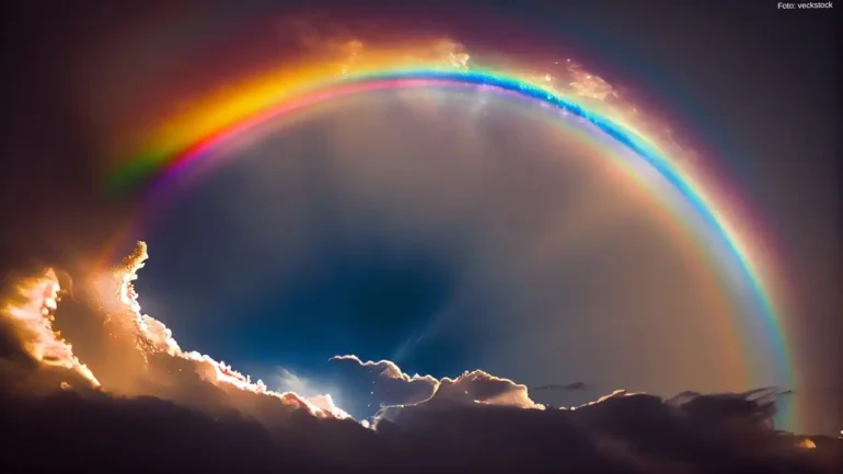 foto com efeito do arco íris no céu, o reflexo da luz solar e o contraste das nuvens bem brancas ao lado. O azul do arco íris se destaca por algum efeito artificial pela inteligência artificial.