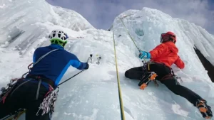 foto de 2 alpinistas escalando uma montanha de gelo.