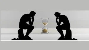 imagem de um homem na posiçAo da estátua do pensador (sentado com o queixo apoiado no punho fechado e o cotovelo na perna de frente para uma ampulheta caindo a areia. A frente dele, também em frente para a ampulheta uma mulher na mesma posição dele de frente para a ampulheta. Deles só vemos a sombra bem definida, cor preta.