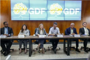 Foto de uma mesa com a vice-governadora do DF Celina Leão, mais 4 homens e uma mulher sentados ao seu lado. Ao fundo um painel do GDF.