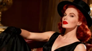 imagem de uma mulher ruiva muito bonita vestindo vestido preto e batom vermelho.